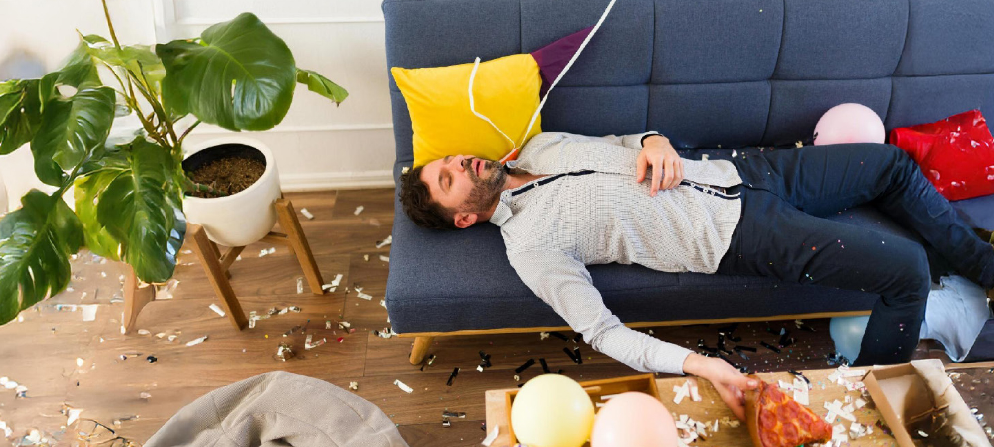 Man passed out on the couch surrounded by mess.