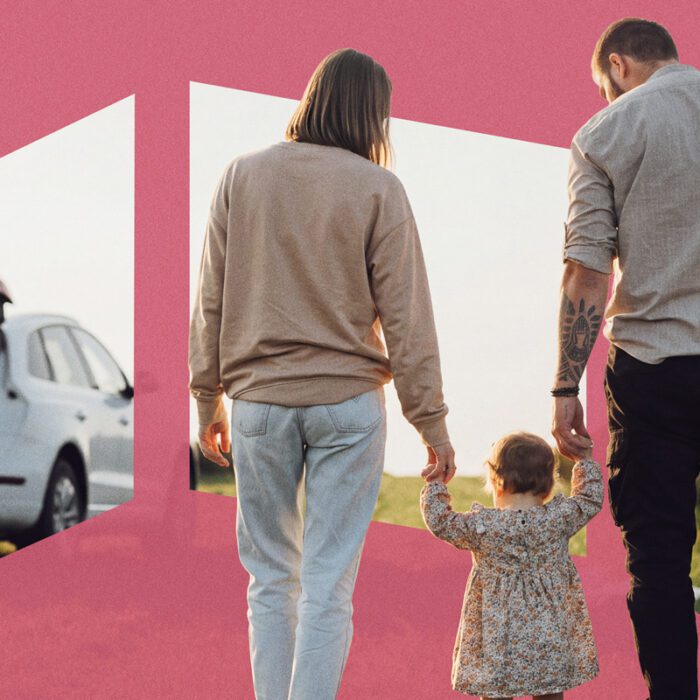 Family of three walking away, holding hands, with car trunk open in background